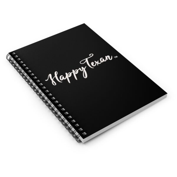 A spiral notebook with the words happy texan written in white on it.