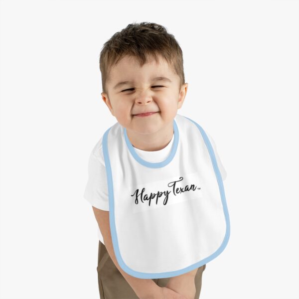 A young boy wearing a bib with the words " happy tears ".