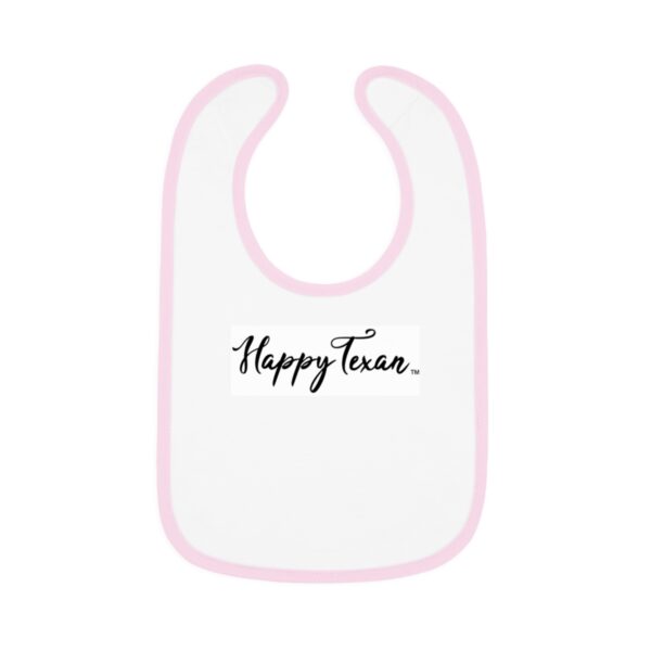 A white bib with pink trim and the words " happy texas ".