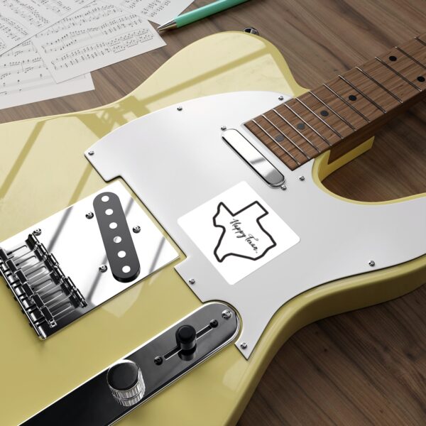 A yellow guitar sitting on top of a wooden table.