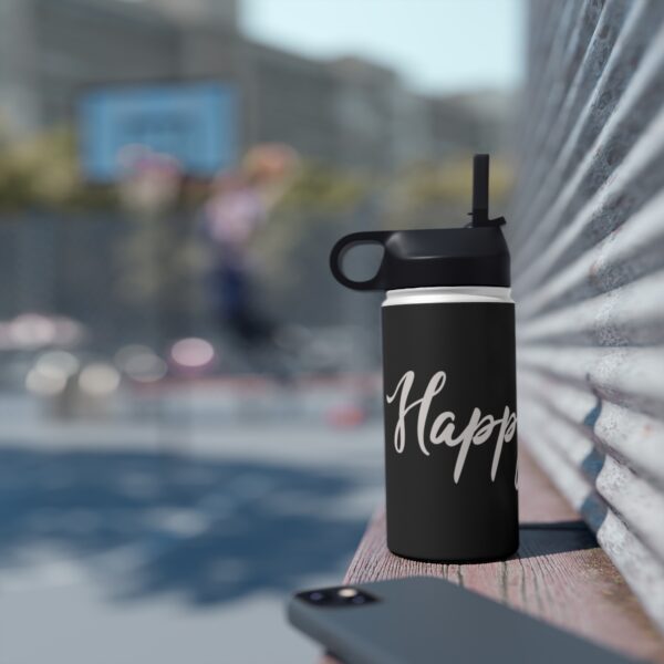 A black water bottle sitting on top of a bench.