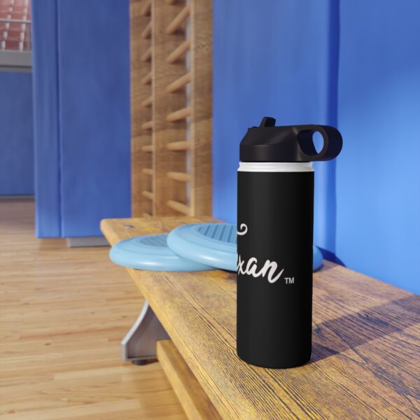 A black water bottle sitting on top of a wooden bench.