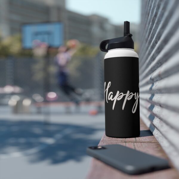 A black water bottle sitting on top of a bench.