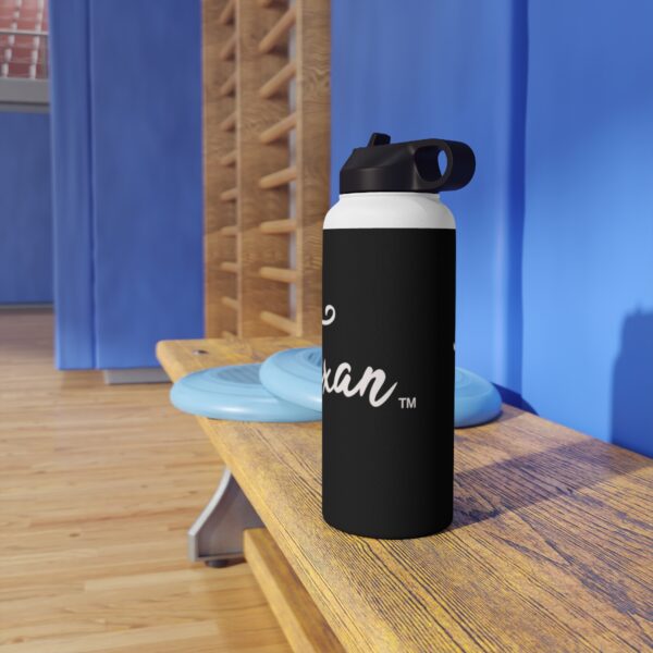 A black water bottle sitting on top of a wooden bench.