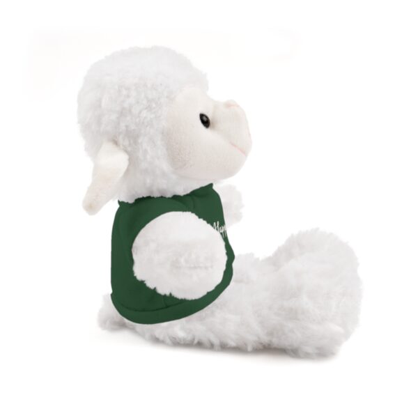 A stuffed animal is sitting down and wearing a green shirt.