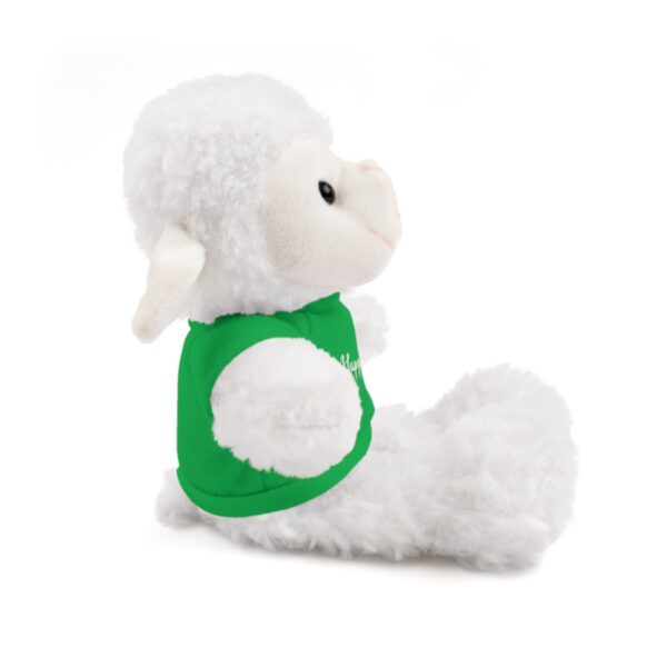 A stuffed animal is sitting down and wearing a green shirt.