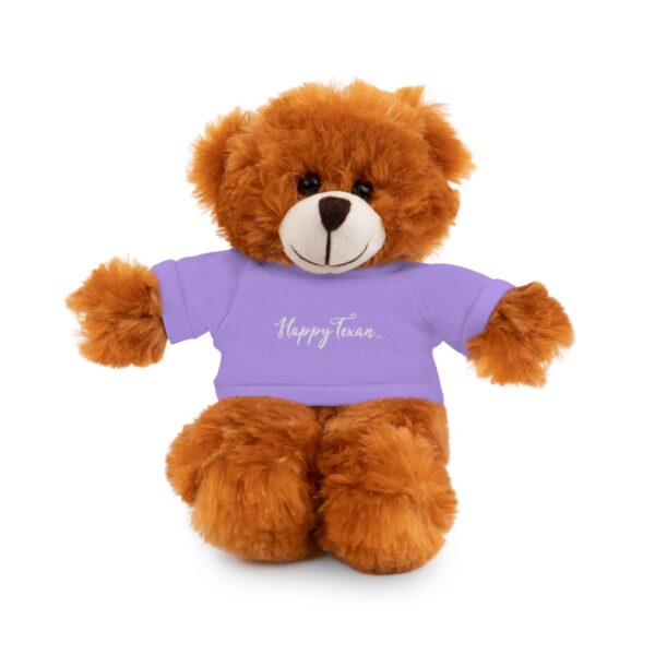 A brown teddy bear wearing a purple shirt.