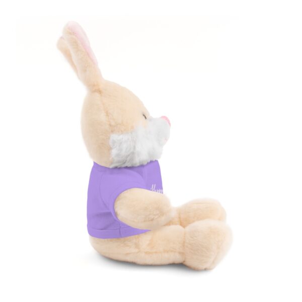 A stuffed bunny rabbit with a purple shirt.