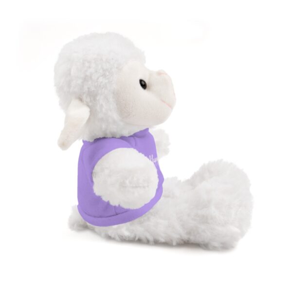 A stuffed animal is sitting down and wearing a purple shirt.