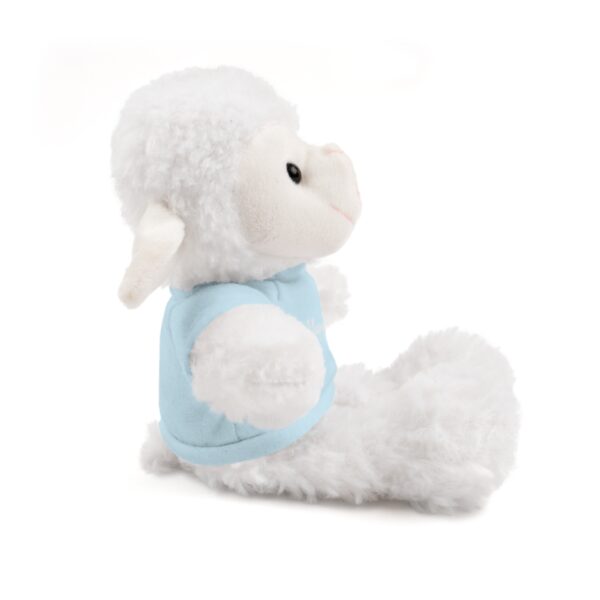 A stuffed animal is sitting down and wearing a blue shirt.