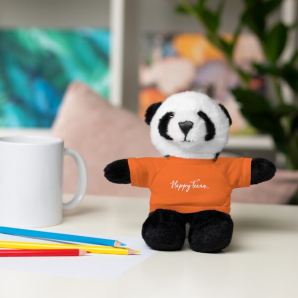 A stuffed panda bear sitting on top of a table.