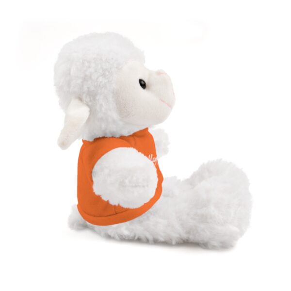 A stuffed animal is sitting down and wearing an orange shirt.