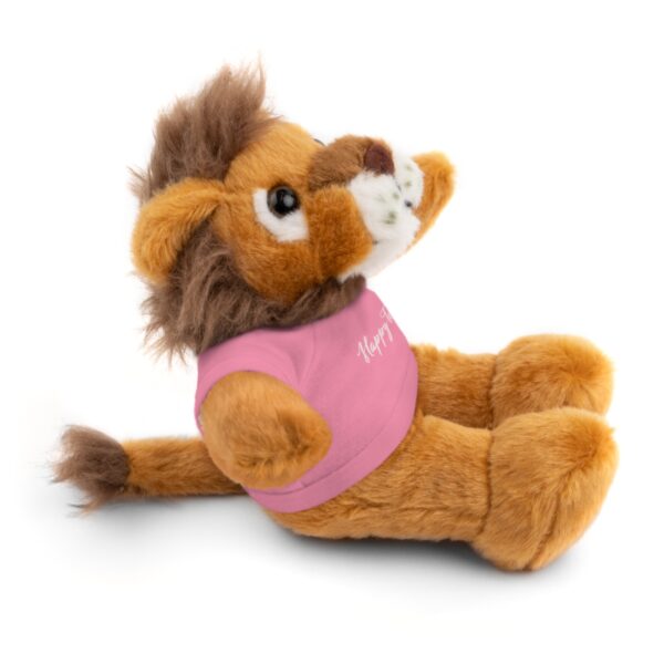 A stuffed lion with pink shirt sitting on the ground.