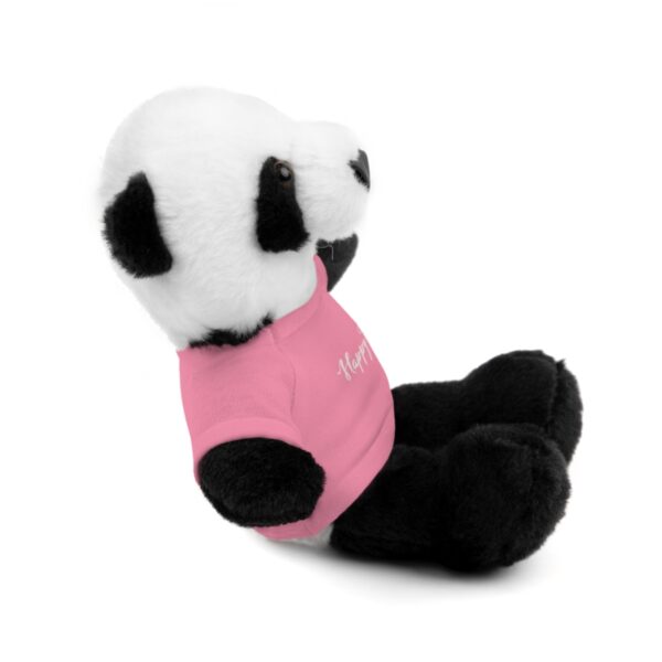 A stuffed panda bear with pink shirt sitting on its back.