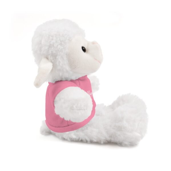 A stuffed animal is sitting down and wearing a pink shirt.