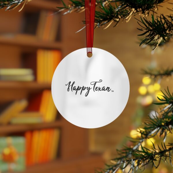 A white ornament hanging from a christmas tree.